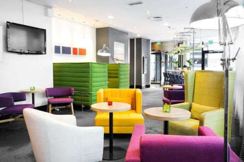 奥斯陆拉蒂森奥斯陆公园旅馆的一间设有五颜六色的椅子和桌子的等候室