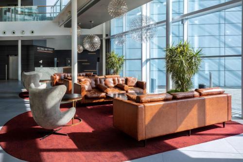 斯丹斯达蒙费雪特伦敦斯坦斯特德机场丽笙酒店的大楼内一个带沙发和椅子的大堂