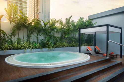 曼谷Radisson Suites Bangkok Sukhumvit的植物建筑中的按摩浴缸