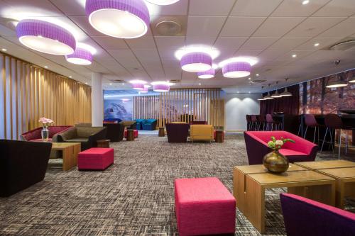 奥斯陆奥斯陆奥纳丽笙酒店的一间设有桌椅和紫色灯的等候室