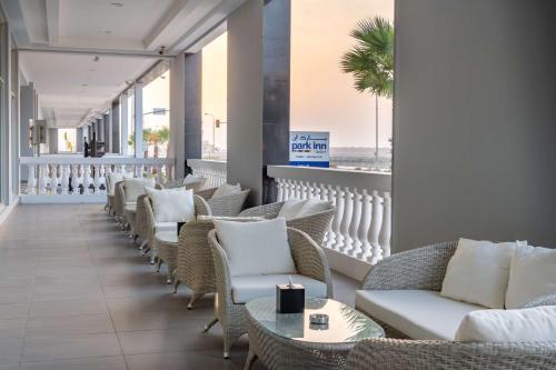 奥朱贝尔Park Inn by Radisson Jubail Industrial City的休息室配有桌椅,享有海滩美景