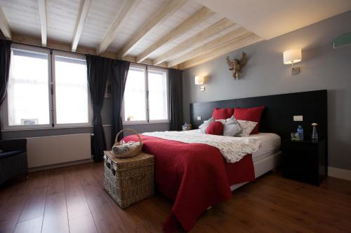 布鲁日安比恩泰客房公寓的一间卧室配有一张带红色枕头的大床