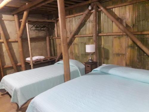 巴耶斯城Eco Hotel Casa Kima的木墙客房的两张床