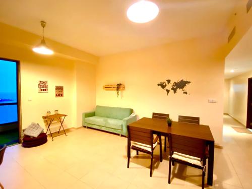 迪拜Bombay Backpackers DXB的客厅配有绿色沙发和桌子