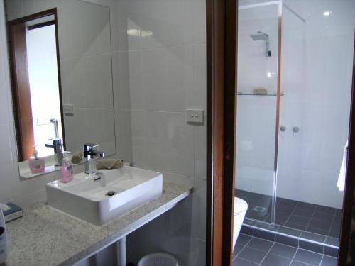 科布勒姆摄政庭院汽车旅馆的浴室配有白色水槽和淋浴。