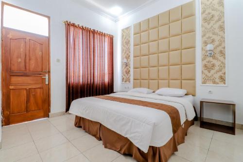 Wonosari歌利亚丽曼山古农齐都尔旅馆的一间卧室设有一张大床和木门