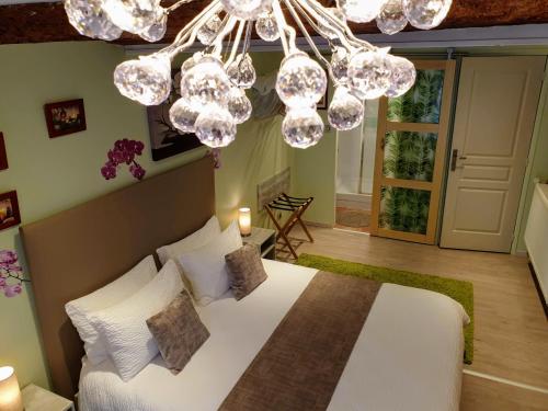 DruillatChambre D´hôtes Léonie & Restaurant的一间卧室配有一张带吊灯的大床