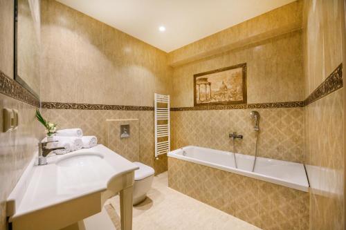 弗洛里纳Emerald Suites的一间带水槽、浴缸和卫生间的浴室