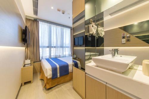 香港朗华酒店的一间带水槽的浴室和一张位于客房内的床
