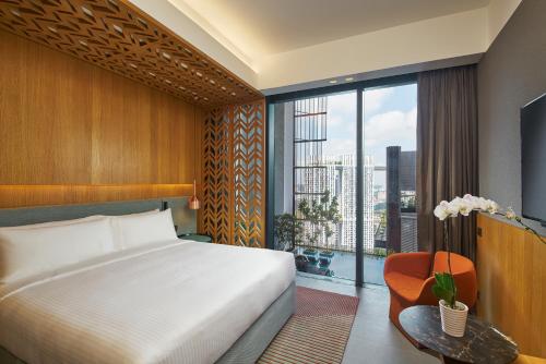 新加坡Oasia Hotel Downtown, Singapore by Far East Hospitality的一间卧室设有一张床和一个大窗户