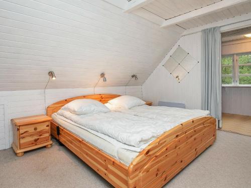 MosevråHoliday Home Grævlingevej II的一间卧室,卧室内配有一张木床