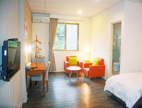 埔里NCNU Campus Inn暨大行旅的酒店客房,配有一张床、一张桌子和椅子