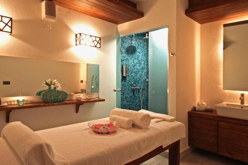 厄吕代尼兹蒙大拿松树全包度假村的浴室设有1张带水槽和淋浴的床铺。