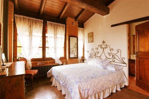 Castello di SerravalleLa Buca的卧室配有一张床、一张书桌和窗户。