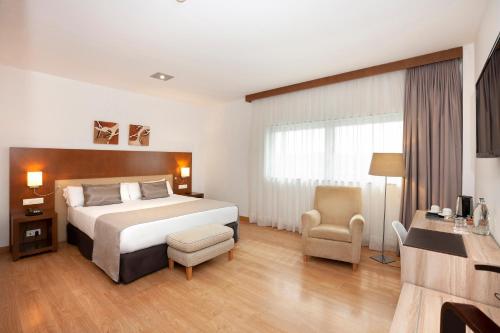 比亚纳B&B HOTEL Logroño Las Cañas的配有一张床和一把椅子的酒店客房
