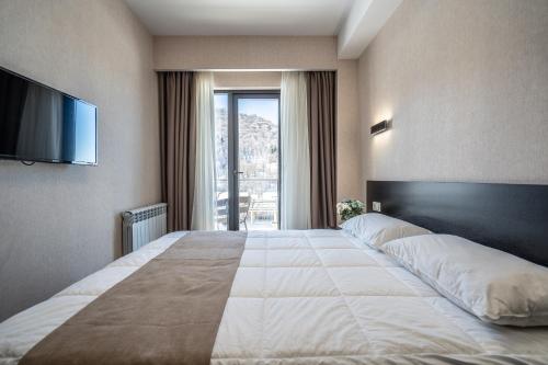 巴库里阿尼Snow Pine Suite - 4 Star Resort的酒店客房设有一张大床和一台电视。