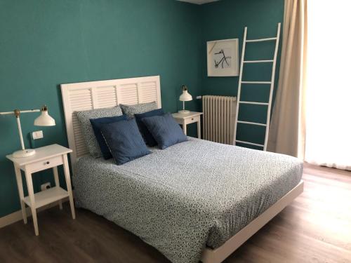 绍莱Au Rez de Jardin的一间卧室配有一张带蓝色枕头的床和梯子