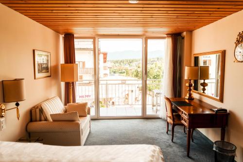 弗利姆斯Hillsite Smart Hotel Flims的酒店客房设有一张桌子、一张床和一个窗户。