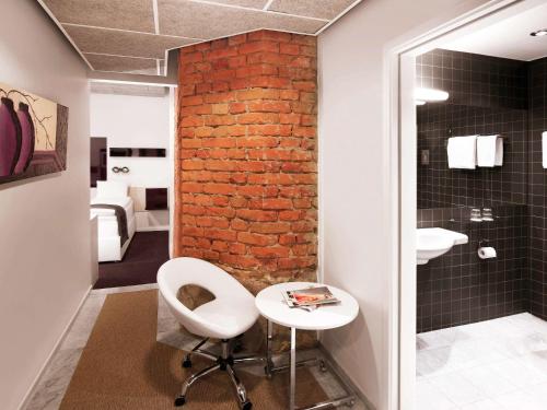 斯德哥尔摩斯德哥尔摩奥登普兰宜必思尚品酒店的浴室设有白色椅子和砖墙