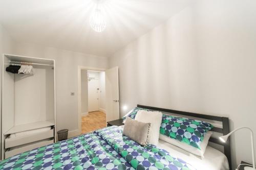 诺里奇Britannia House 1 bed apartment的一间卧室配有一张带蓝色和绿色枕头的大床
