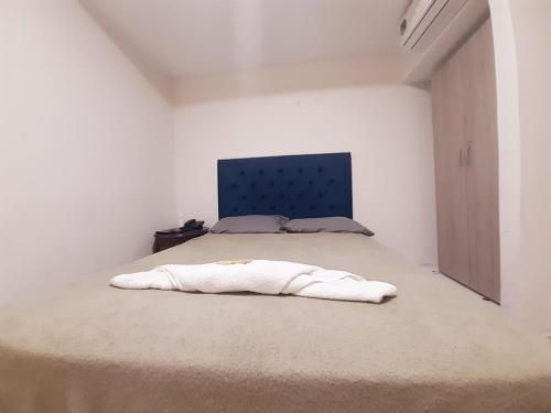巴兰基亚Villa Mary Hostal的白色卧室,配有一张蓝色床头板的床
