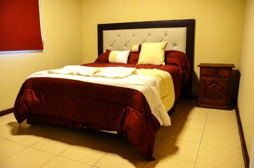 玛利亚镇La Isolina Club de Campo的一间卧室设有一张大床和一个木制床头柜