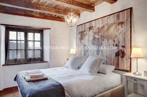 巴奎伊拉-贝莱特Apartamento Era Cascada By Totiaran的卧室配有一张带吊灯的大型白色床。