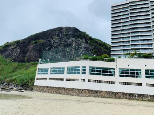 瓜鲁雅Apartamento Praia Guarujá的山边海滩上的建筑
