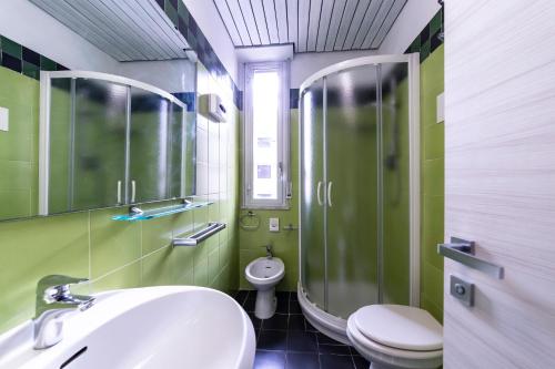 里米尼Park Hotel的一间带水槽、淋浴和卫生间的浴室