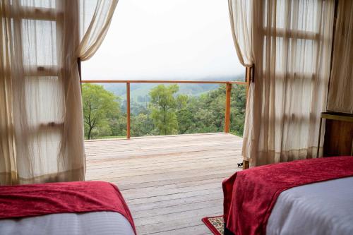 萨兰托Birdglamping Los Arboles Glamping Hotel的一间卧室享有木甲板的景色