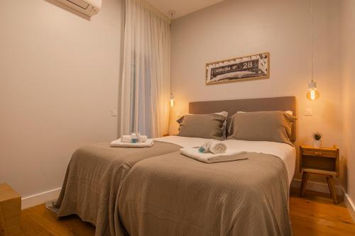 里斯本Upscale & Modern 2BDR Apartment的一间卧室配有两张带毛巾的床