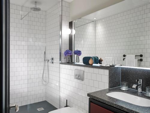 都柏林The Mont的白色瓷砖浴室设有水槽和镜子
