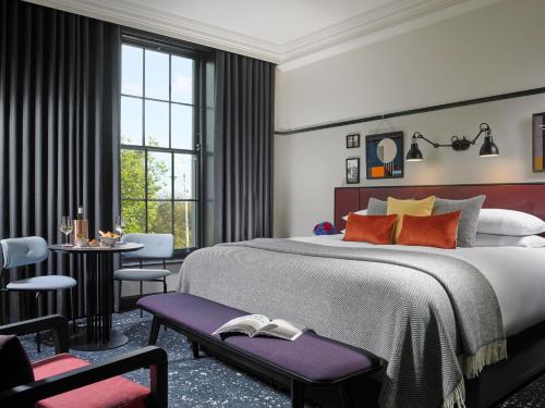 都柏林The Mont的一间卧室配有一张大床和一张桌子及椅子