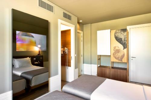 里斯本罗西奥我的故事酒店的一间卧室设有两张床,一扇门通往房间