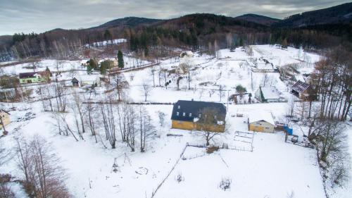 Stará Červená VodaPenzion PIŠLIKDUM的一座小村庄,有房子,积雪覆盖着