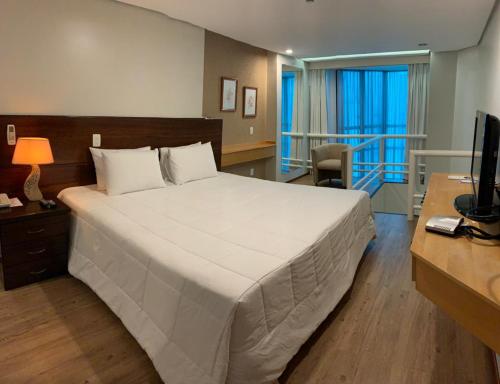大坎普巴哈马酒店的卧室配有一张白色大床和一张书桌