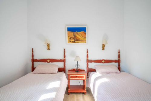 瓜达拉马La "Casita" de la Sierra的一间卧室配有两张床,中间设有床头柜。
