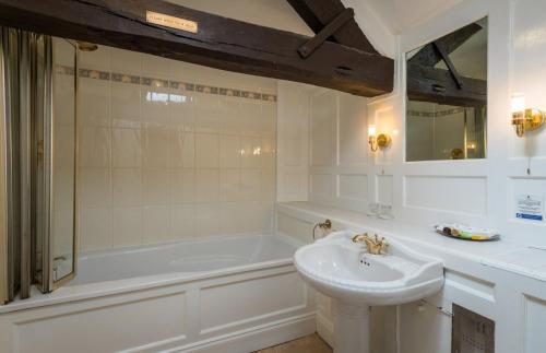 锡斯凯尔Sella Park Country House Hotel的白色的浴室设有水槽和浴缸。
