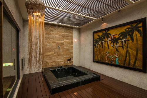 树林区金莎汽车旅馆的浴室配有浴缸,墙上挂有绘画作品