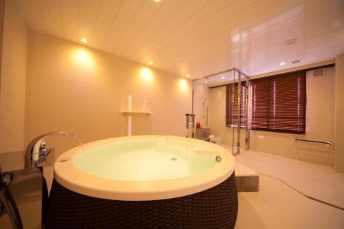 熊本其宽温泉域贝尔酒店的客房内的浴室设有大浴缸