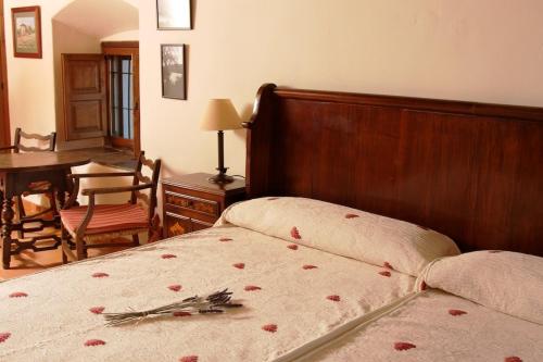 托雷洪厄尔卢比奥科查拉斯老宫殿旅馆的一间卧室,床上有红色玫瑰