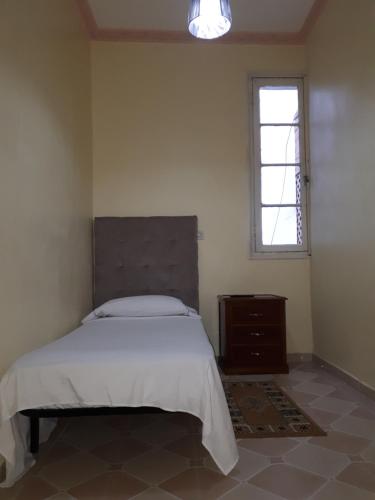 丹吉尔Pension Safari的一间卧室设有一张大床和一个窗户。