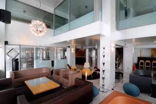 斯巴达玛尼阿缇斯酒店的客厅配有皮革家具和吊灯。