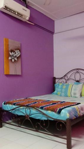 关丹Bajet Homestay - low cost houses的一间卧室配有一张紫色墙壁和床