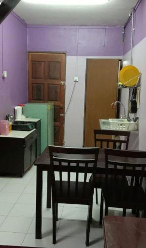 关丹Bajet Homestay - low cost houses的厨房配有桌椅和紫色墙壁