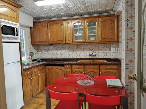 莫莱拉Apartamentos Gladys的厨房配有红色的桌子和红色的椅子
