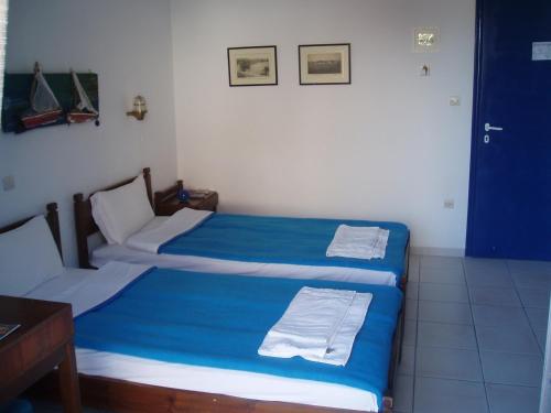 阿吉亚玛丽娜Helios Hotel的蓝色床单间内的两张单人床
