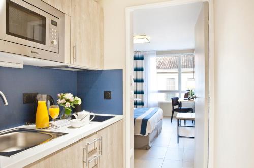 马赛Residhome Marseille的一个带水槽的厨房和一张位于客房内的床