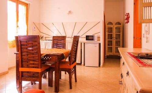 阿尔盖罗Marisal Accommodation的厨房配有桌椅和冰箱。