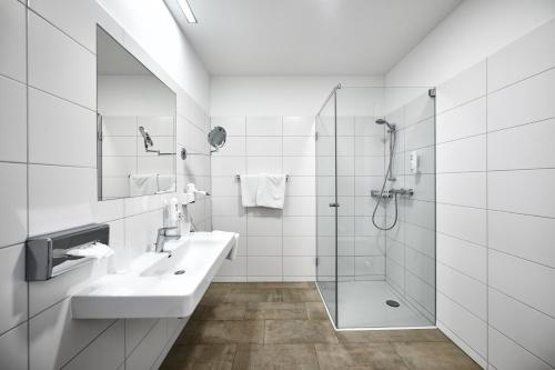 TumeltshamHotel Gasthof-Strasser的白色的浴室设有水槽和淋浴。